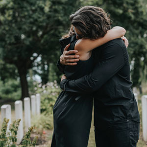 A couple hugging in front of a graveyard - Legal Advantage Group