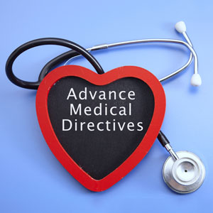 Heart-shaped sign with 'Advance Medical Directives' beside a stethoscope on a blue background